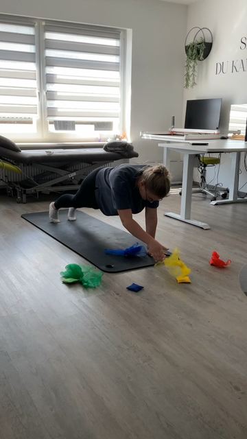 Standbild: Eine Therapeutin stützt sich auf einer Matte ab und greift nach bunten Tüchern